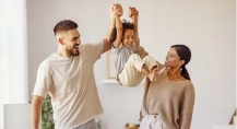 Mother and father swinging their child from their hands