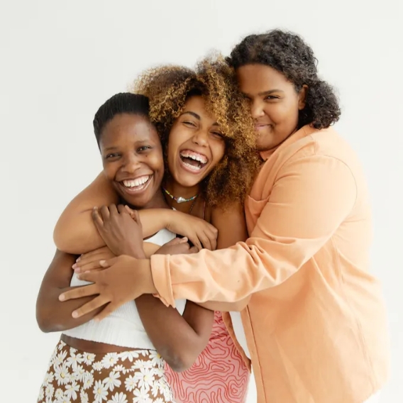 Three smiling woman hugging each other