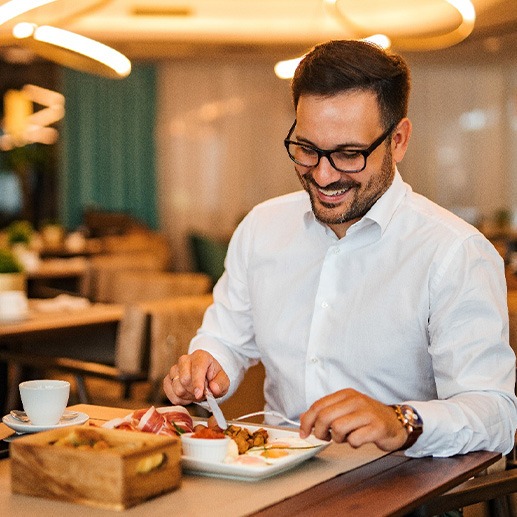 Man smiling while enjoying meal at restaurant