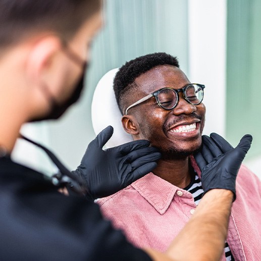 Dentist looking at smiling's patients teeth