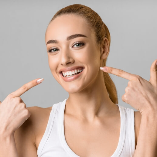 Woman pointing to her smile