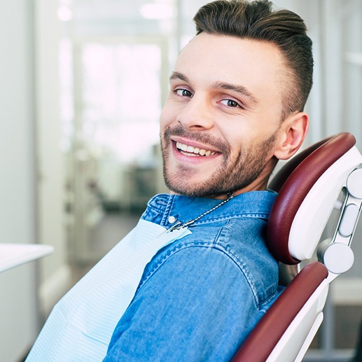 Patient smiling while sitting in dentist treatment chair