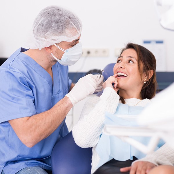 A woman showing her dentist where her toothache is