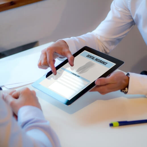 Two people looking at dental insurance information on tablet