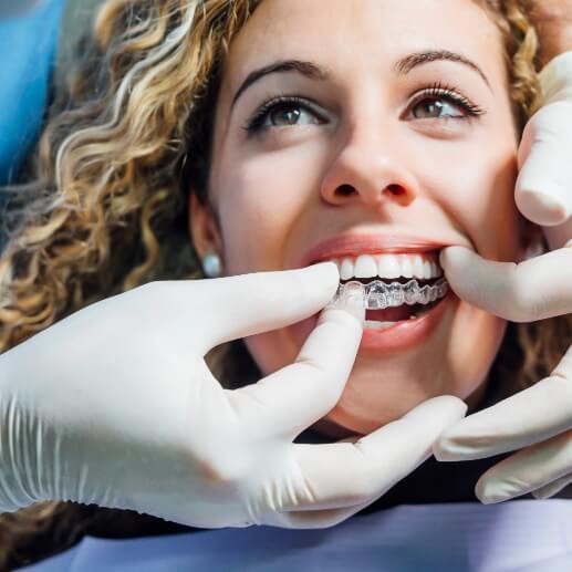 Dentist fitting a patient with an Invisalign aligner