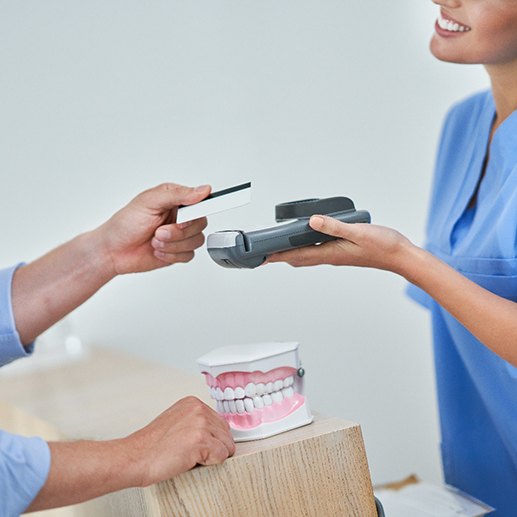 A patient using a credit card to pay for their dental care